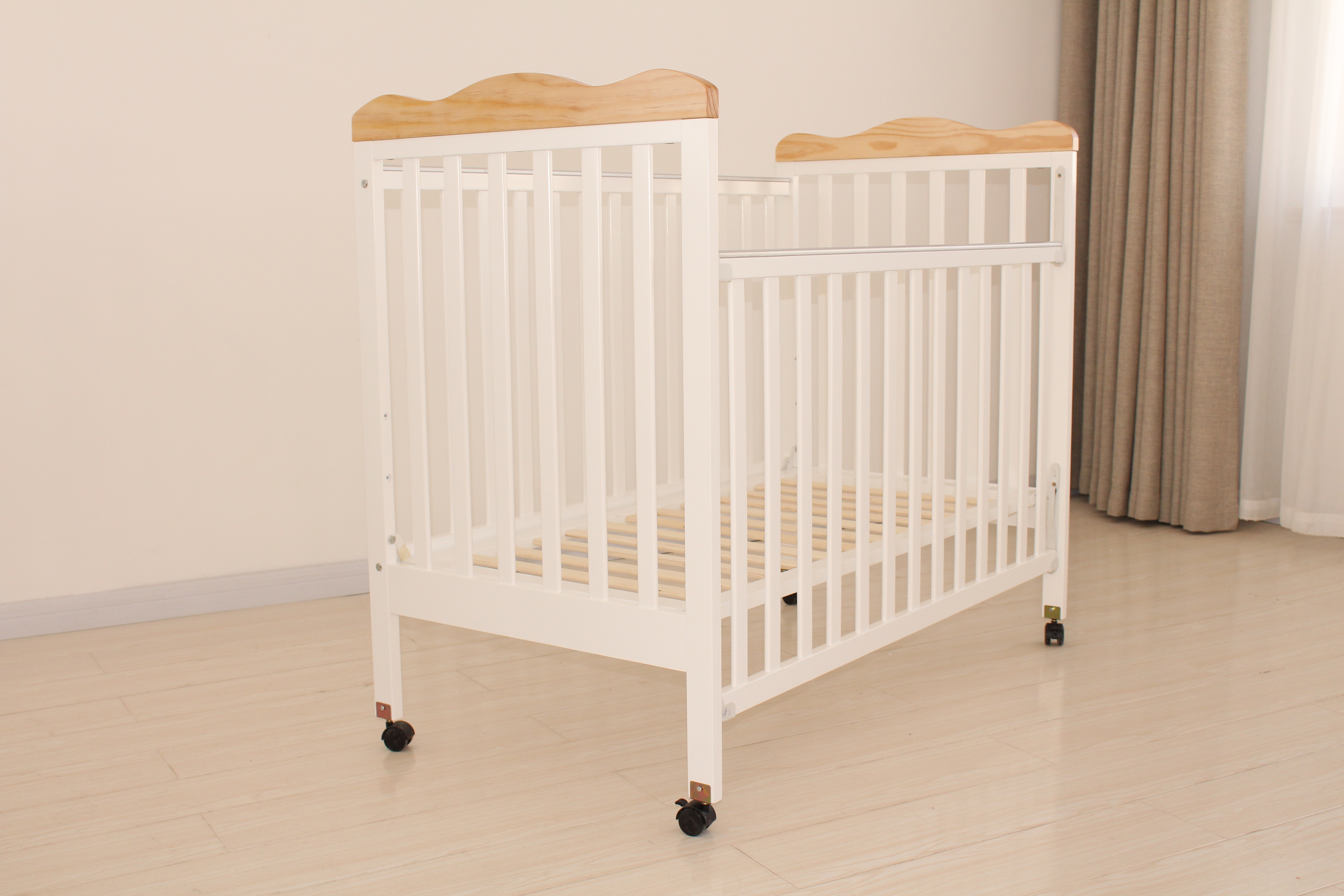 Modern mobile baby crib with safety locks in a bright nursery